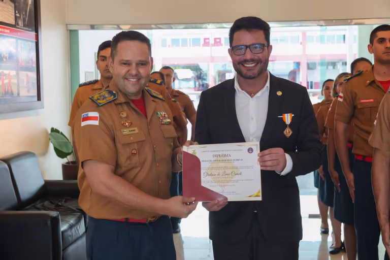 Gladson Cameli ao lado de um oficial do Corpo de Bombeiros, segurando um diploma