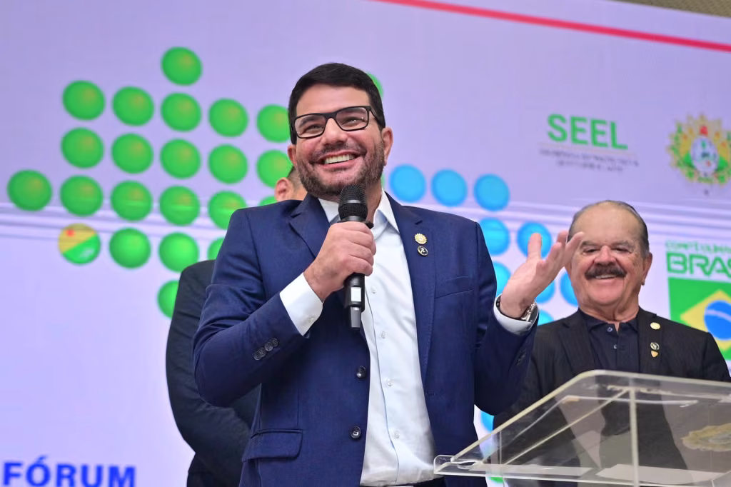Gladson Cameli fala ao microfone em um púlpito, durante uma conferência